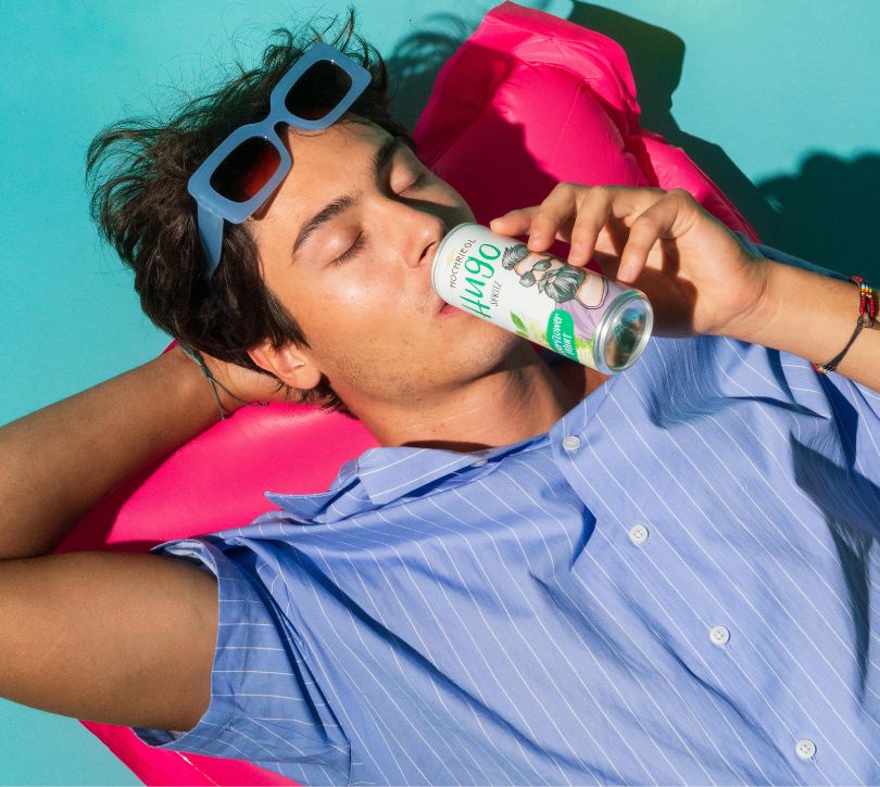 Hann liegt auf Luftmatratze und trinke Hugo Spritz