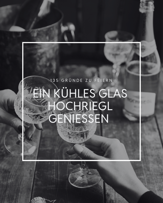 Zwei Personen stoßen mit Sekt an, im Hintergund steht ein Glas Hochriegl Rosé