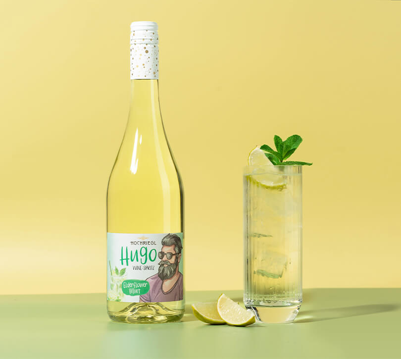 Hugo Flasche und Glas mit Hugo Drink und Limette