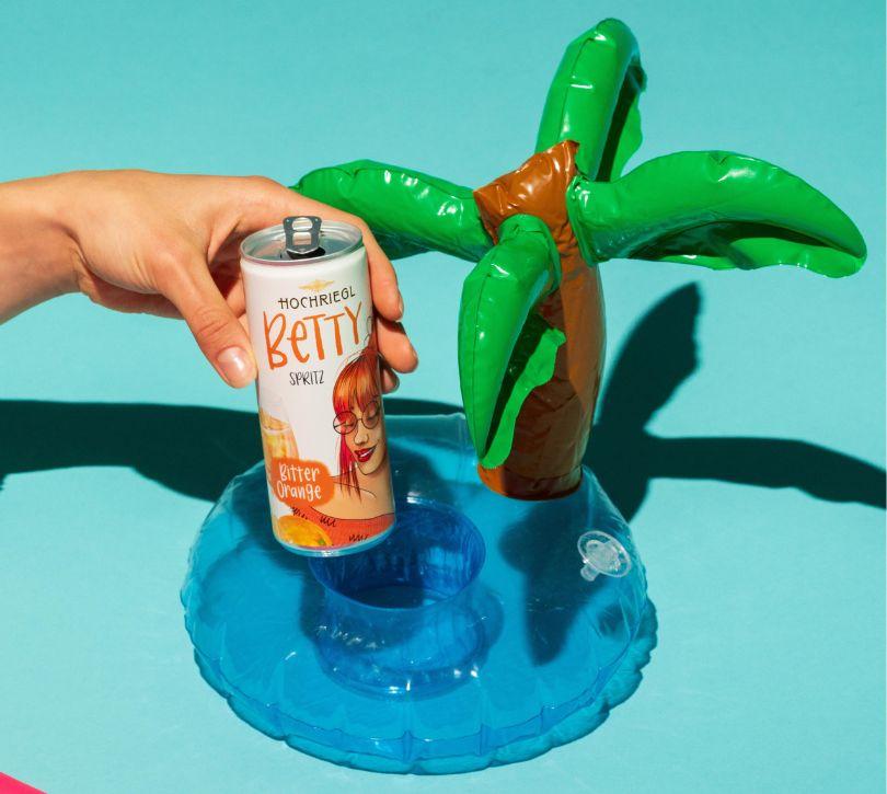 Person nimmt Betty Dose aus Drink-Halter in Form einer Palme