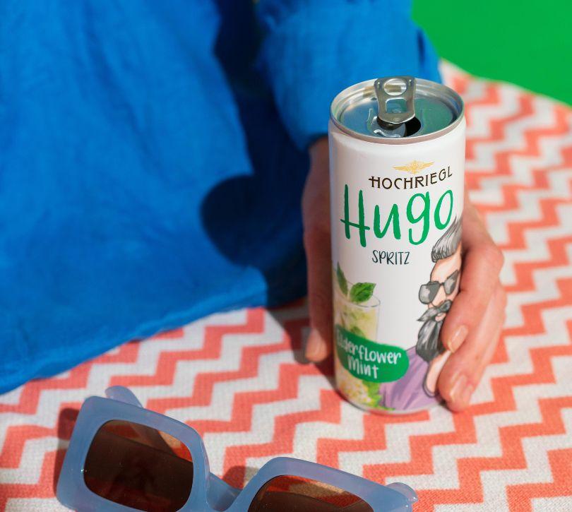 Dame haltet Hugo Dose auf Decke sitzend