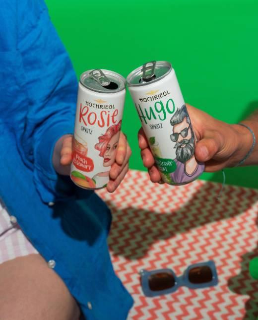 Paar stoßt mit Hugo & Betty Spritz Dosen an