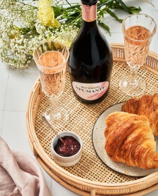 Spumante Rossato mit Gläser und Croissant auf Tisch