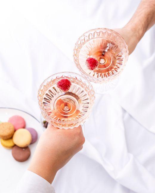 Anstoßen mit zwei Sektschalen mit Rosé